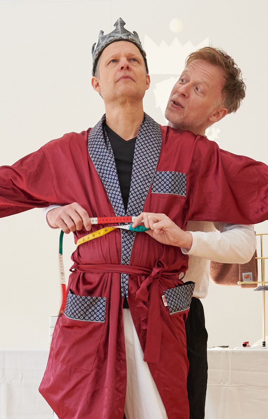 Ein Kaiser wird von einer Schneiderin vermessen